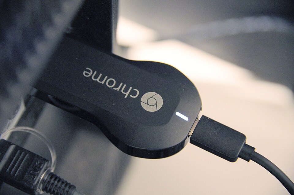 Chromecast conectat langa un televizor pornit, pregatit pentru streaming iptv chromecast
