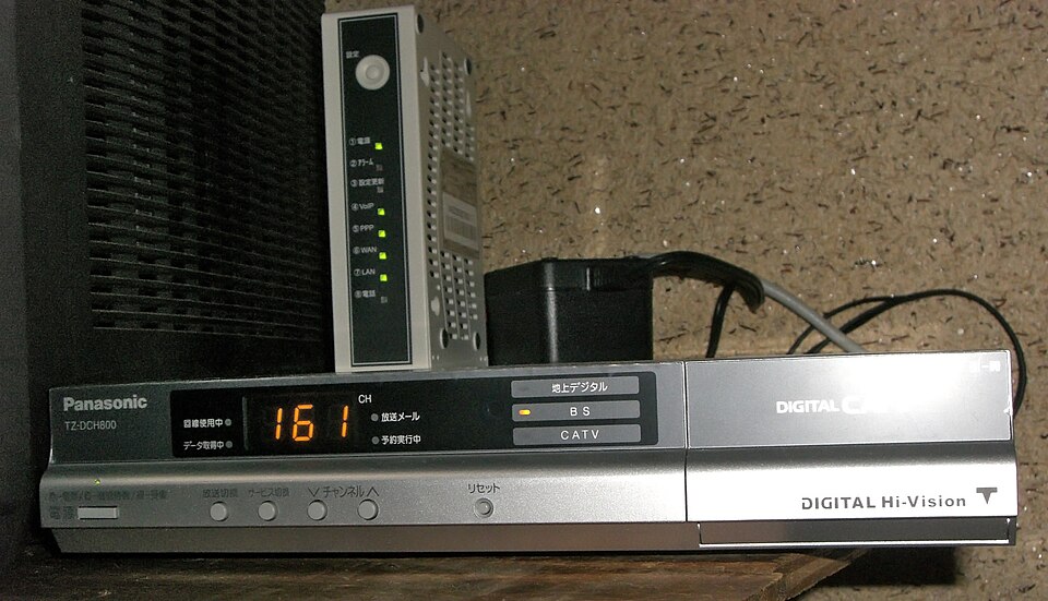 Telecomandă folosită pentru navigarea canalelor IPTV pe televizor, ilustrând simplitatea utilizării unui abonament IPTV